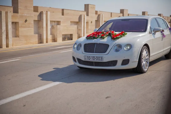 Zbliżenie obraz ślubu dekoracji samochodu z czerwonym i białym bukiet kwiatów — Zdjęcie stockowe