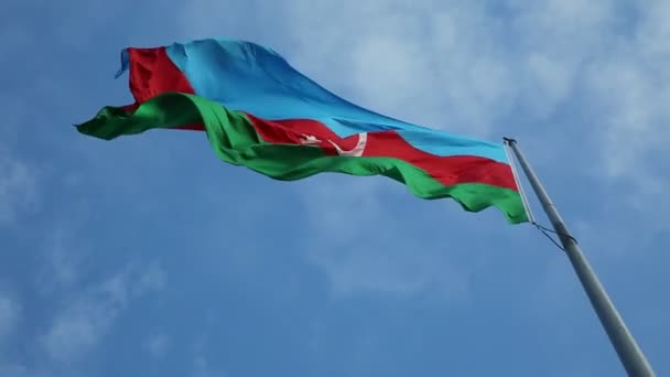 Государственный флаг Азербайджана на фоне голубого неба. Флаг Азербайджана, размахивающий ветром против облачного неба — стоковое видео