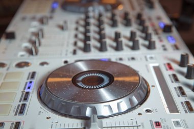 Beyaz DJ aparatı. Gece kulübü için dijital masa örtüsü. Profesyonel konser DJ pikabını ses karıştırıcı paneli ve koşu tekerleği ile çalma aygıtı.