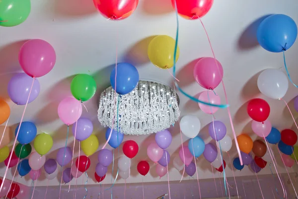 Цветные воздушные шары плавают на белом потолке в комнате для вечеринки. Свадьба или детский день рождения украшения интерьера. Гелиевые шарики. люстры. candelabrum — стоковое фото