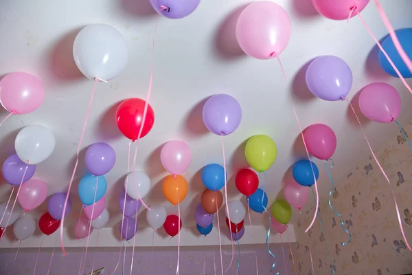 Globos de colores flotan en el techo blanco de la habitación para la fiesta. Boda o niños cumpleaños fiesta decoración interior. Globos de helio. lámpara de araña. candelabro — Foto de Stock