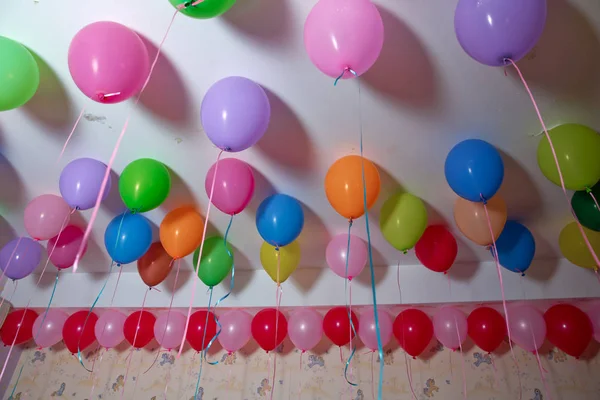 Globos de colores flotan en el techo blanco de la habitación para la fiesta. Boda o niños cumpleaños fiesta decoración interior. Globos de helio. lámpara de araña. candelabro — Foto de Stock