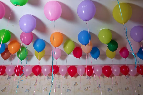 Globos de colores flotan en el techo blanco de la habitación para la fiesta. Boda o niños cumpleaños fiesta decoración interior. Globos de helio. lámpara de araña. candelabro — Foto de Stock