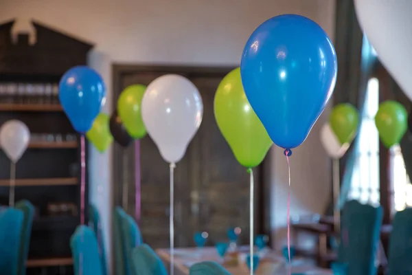 Decorated balloons for birthday. View of an empty blue boyl baptism celebration. B irthday party of a baby concept made of balloons. The blue, white, green balloons attached to the table.