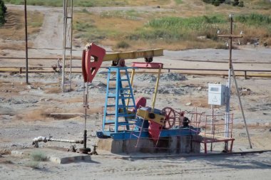 Kiriş tipi krank denge pompalama ünitesi. Petrol çıkaran kuruluş, petrol sahası. Pompalama ünitesi petrol sahasında çalışmaktadır. Kiriş tipi krank denge pompalama ünitesi .