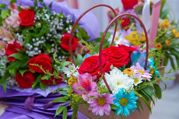 Papírové kytice z různobarevných růží. Růžový obrázek z červeného květu je blízko kytice. Papírová kytice čerstvých červených, bílých, modrých, fialových růží . — Stock fotografie