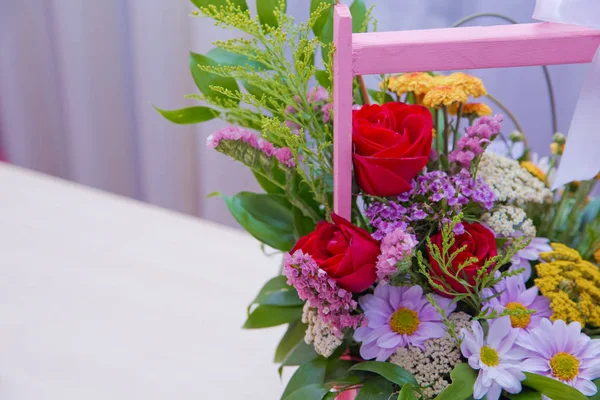 Pink bouquet of multicolored roses . Red , purple flower picture close up in the bouquet. Ribbon . Pink bouquet of fresh purple, red, Pink, white , blue, orange roses .