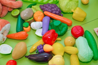 Sahte meyve ve sebzeler. Meyve ve sebze şeklinde plastik çocuk oyuncakları. Oyuncak meyveler ve otlar .