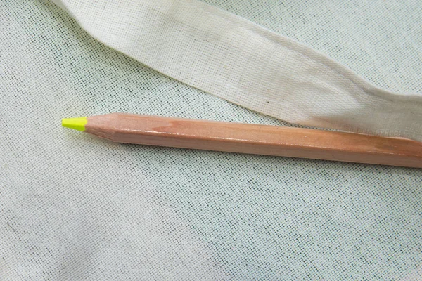 Yellow colored pencil One single object, top view, bright tint. Yellow color pencil on white background. Top surface brown pencil .