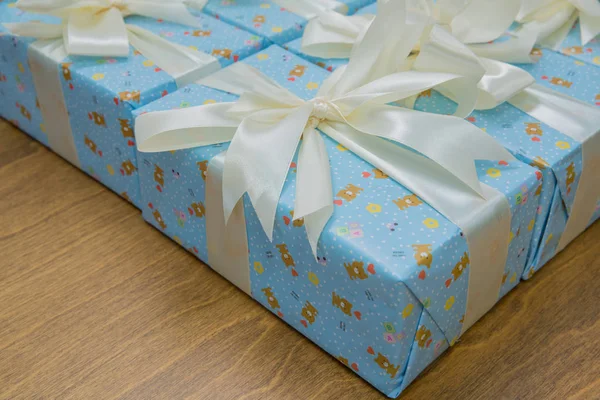 Cadeau, geïsoleerd op houten achtergrond. Groep van blauwe geschenkdozen met zilveren linten geïsoleerd op witte achtergrond met uitknippad. Blauwe geschenkdozen met een wit lint en strik . — Stockfoto