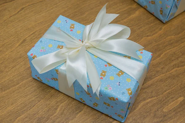 Cadeau, geïsoleerd op houten achtergrond. Groep van blauwe geschenkdozen met zilveren linten geïsoleerd op witte achtergrond met uitknippad. Blauwe geschenkdozen met een wit lint en strik . — Stockfoto