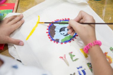 Guaj ve boyama ve çocuk çizim için kağıt. Çocuk elleri sanat malzemeleri ile masada boyama, üst görünümü . Üst te çocuk elleri kağıda guaj çiziyor.