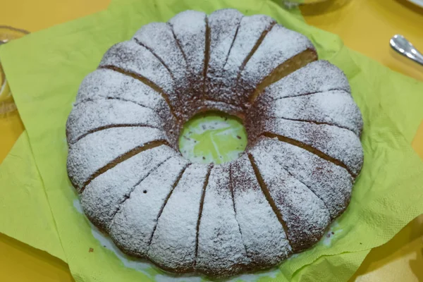 Hausgemachter Kuchen mit Puderzucker. hausgemachter Bündelkuchen mit weißem Mehl auf grünem Hintergrund. — Stockfoto