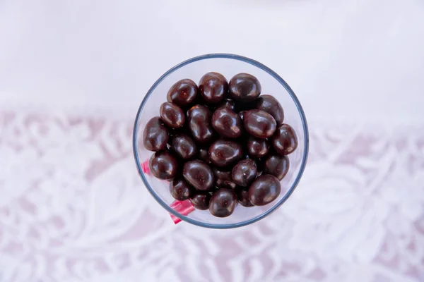 Boules de chocolat noir avec cœur d'amande. dans un bocal en verre.Dans un verre rond au chocolat noir. Boules de bonbons au chocolat noir dans un bol en verre sur fond blanc, isolé  . — Photo