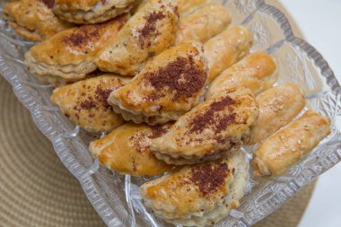 Fırında pişmiş turta. Beyaz bir tabak ve şeftali rengi arka plan üzerinde. Et, lahana veya herhangi bir dolgu ile Pies.