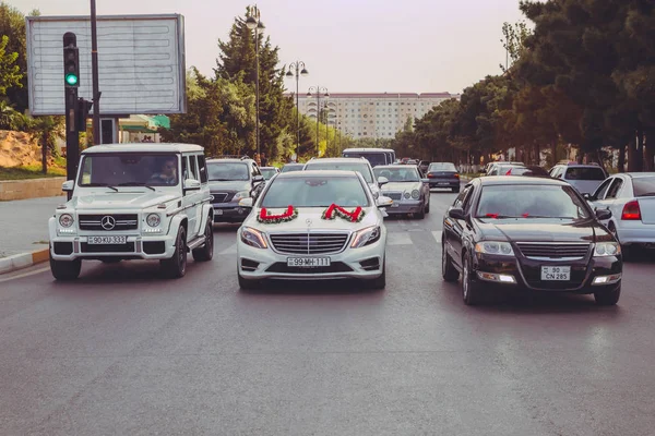 Hochzeitskortege im Stadtzentrum von Baku. Hochzeitskortege an der Spitze des Autos. rote und weiße Blumen Strauß. Nahaufnahme Bild der Hochzeit Auto Dekoration. Straße. Straße als Teil des Hochzeitskorteges . — Stockfoto