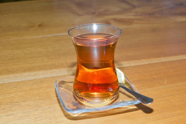 Thé en verre traditionnel armudu azerbaïdjanais en forme de poire. Thé noir Azerbaïdjan avec table vintage en bois. Thé turc noir en verre en forme de poire, thé aromatique azerbaïdjanais traditionnel en tasse armudu  . — Photo