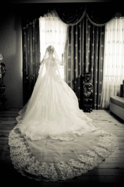 Beyaz düğünlü gelin. Beyaz gelinlikli güzel gelin pencerenin yanında duruyor. .