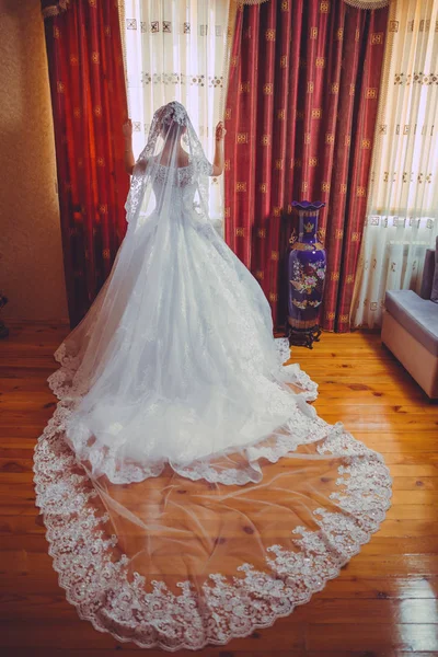白い結婚式の花嫁。美しいです花嫁で白いウェディングドレス立って彼女のベッドルームの近くにザ · ウィンドウ . — ストック写真