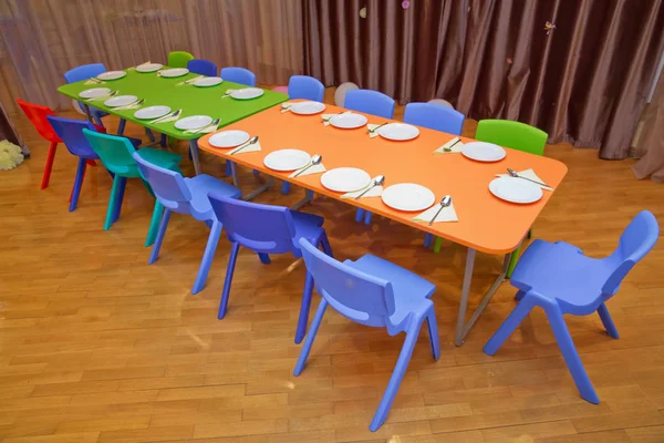 Kindermeubels en speelgoed in de kleuterschool. kleuterschool klasse met de groene stoelen en kleine tafels. School kleuterklas kinderkamer eetkamer . — Stockfoto