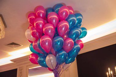 Mavi gökyüzünde mutlu kutlama ile Balonlar . Bir demet pembe ve mavi balon. Mutluluk kavramı, sevinç, aşk, doğum günü, düğün. Gökyüzünde uçan mavi ve pembe balonlar .