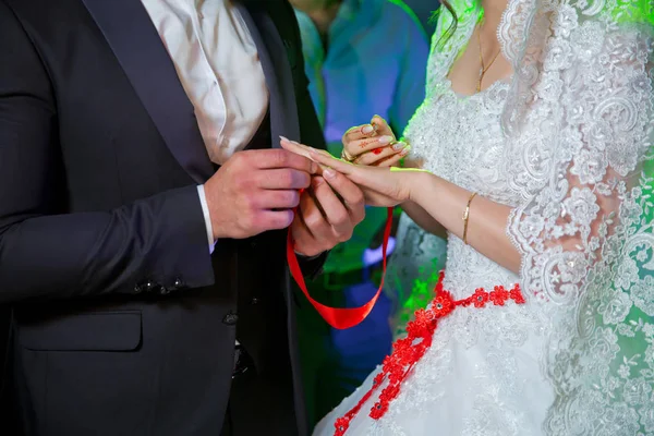 신랑은 교회에서 신부의 손에 결혼 반지를 넣습니다. 남자는 신부의 손에 결혼 반지를 두고, 클로즈업 사진. 신부의 손에 반지를 끼우다 . — 스톡 사진