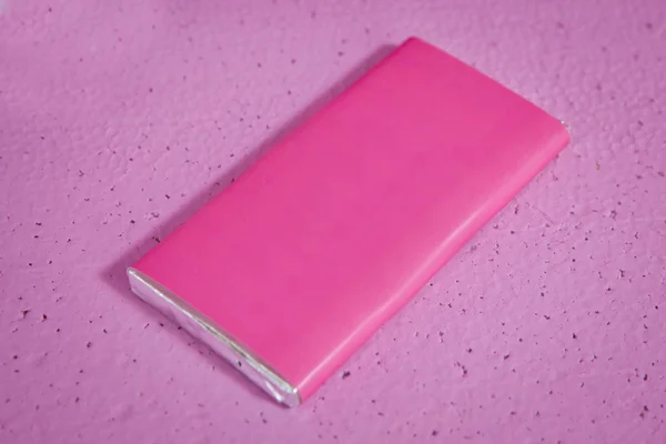 设计理念。白纸巧克力包装隔离在粉红色上。粉红色背景上的粉红色框模板的特写。巧克力。包。全系列巧克力系列. — 图库照片