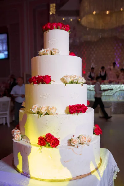 Gourmet tiered wedding cake at wedding reception .5 level wedding cake with flowers . five-layer cake.