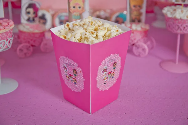 Eine große klassische Schachtel Theater-Popcorn isoliert auf rosa. einfache Dekoration von Babynamen mit lol-Cartoons in der Stadt Azerbaijan. dekorierter lol Tisch zum Geburtstag . — Stockfoto