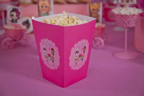 Eine große klassische Schachtel Theater-Popcorn isoliert auf rosa. einfache Dekoration von Babynamen mit lol-Cartoons in der Stadt Azerbaijan. dekorierter lol Tisch zum Geburtstag . — Stockfoto