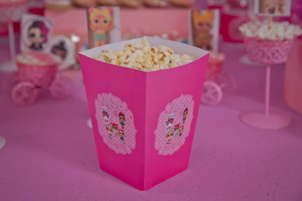 Eine große klassische Schachtel Theater-Popcorn isoliert auf rosa. einfache Dekoration von Babynamen mit lol-Cartoons in der Stadt Azerbaijan. dekorierter lol Tisch zum Geburtstag . — Stockfoto