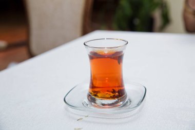 Azerbaycan geleneksel armudu armut şeklinde cam çay . Vintage beyaz masa ile Azerbaycan siyah çay . Armut şeklinde cam siyah türk çayı, armudu fincan geleneksel Azerbaycan aromatik çay .