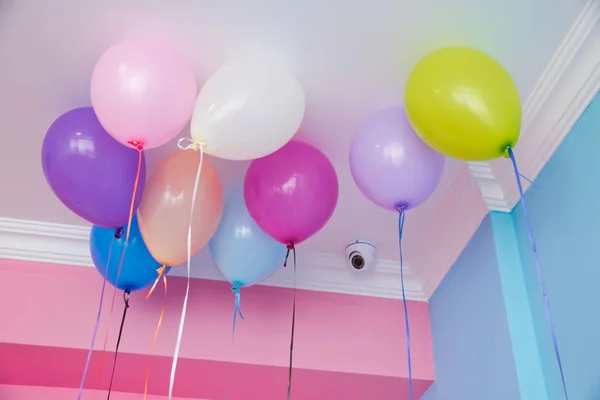 Цветные воздушные шары плавают на белом потолке в комнате для вечеринки. Свадьба или детский день рождения украшения интерьера. Гелиевые шары  . — стоковое фото