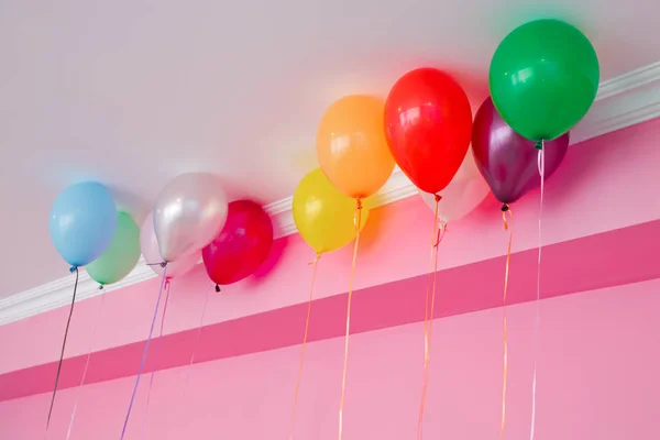 Balões coloridos flutuam no teto branco na sala para a festa. Casamento ou crianças decoração de festa de aniversário interior. Balões de hélio  . — Fotografia de Stock