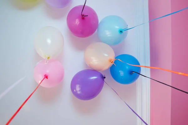 Bunte Luftballons schweben an der weißen Decke im Partyraum. Hochzeit oder Kindergeburtstag Dekoration Innenraum. Heliumballons . — Stockfoto