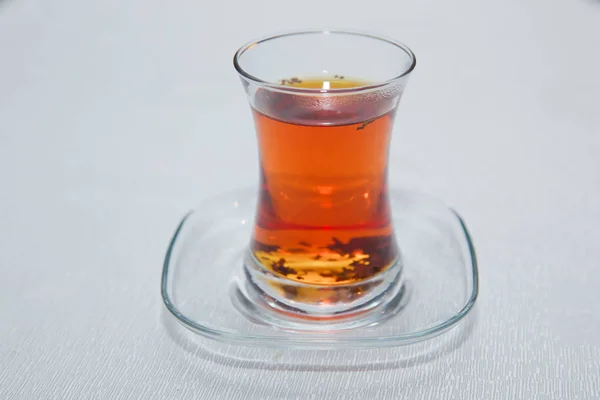 Té en Azerbaiyán tradicional armudu en forma de pera de vidrio. Azerbaiyán té negro con mesa blanca vintage. Té turco negro en vidrio en forma de pera, té aromático tradicional azerbaiyano en taza de armudu  . — Foto de Stock