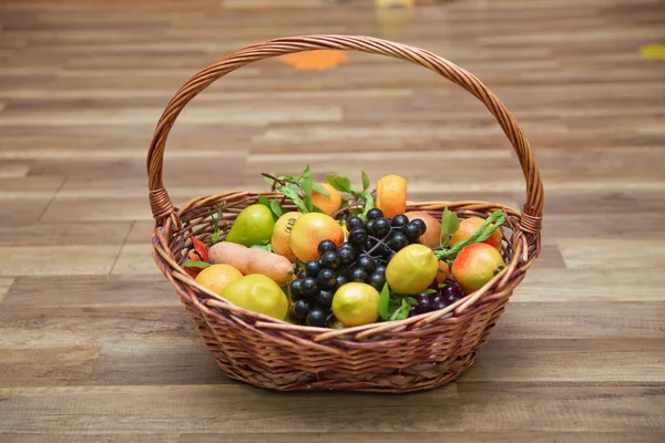 Pommes, prunes et un frêne de montagne dans un panier, vue sur le dessus. Nature morte à table. Agrumes frais juteux dans un panier sur un fond en bois. Panier et fruits frais sur table en bois  . — Photo