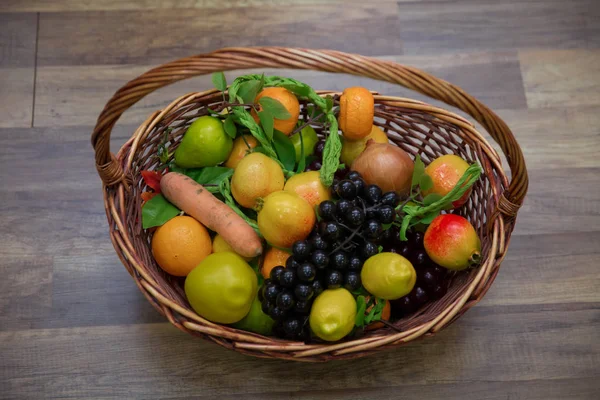 Pommes, prunes et un frêne de montagne dans un panier, vue sur le dessus. Nature morte à table. Agrumes frais juteux dans un panier sur un fond en bois. Panier et fruits frais sur table en bois  . — Photo