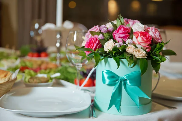 Beautiful bouquets of pink, white, yellow and red flowers in the round box . Red and purple flower bouquet in round green box .