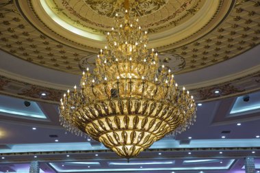 Kilisede yanan mumlarla yaldızlı avize. Barok tarzda büyük kristal avize. Güzel bir kristal avize yakın çekim .