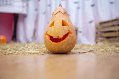 Ürkütücü Cadılar Bayramı Jack o Lantern. Bir arka plan üzerinde sonbaharda kuru saman kabak. Cadılar Bayramı'na hazırlık için. Halloween kabak en kötü şekilde sırıtarak.