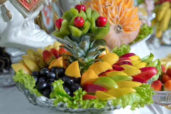 Tál szeletelt szezonális gyümölcsök, mint a Kiwi, ananász, borda, citrom, Alma fogyasztásra kész. Egészséges táplálkozás és életmód. Friss és természetes gyümölcs egy kis szünetért. Apróra vágott gyümölcsöt egy üvegedénybe. — Stock Fotó