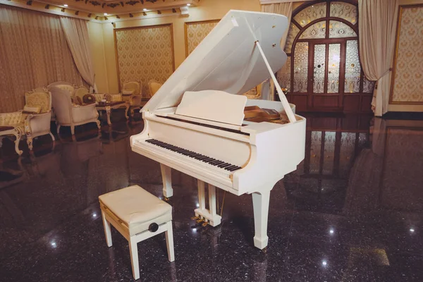 Biały fortepian i krzesło. białego fortepianu w hali. Piano Conner na relaks i odtwarzanie muzyki. — Zdjęcie stockowe