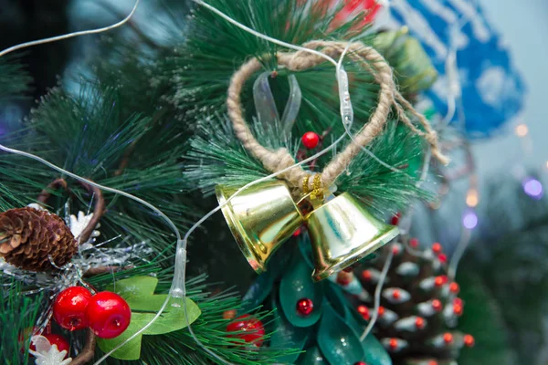 Рождественские золотые колокола с рождественской отделкой украшены на фоне сосны. колокол с желтым шаром перед елкой. Новогодние игрушки. колокол украсить на елку . — стоковое фото