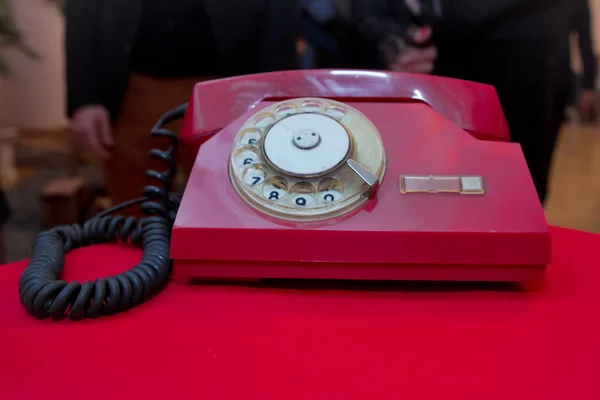 Contáctenos Concepto. Vida con teléfono rojo retro en mesa roja de madera sobre fondo grunge. Teléfono analógico vintage antiguo rojo marcando o desplazando el teléfono en la mesa roja . —  Fotos de Stock