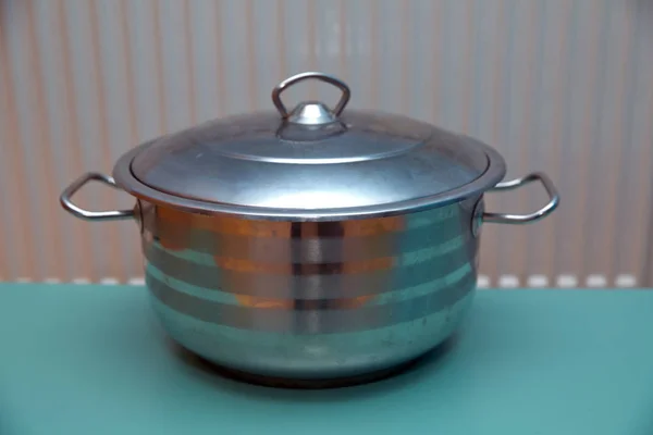 Metal pan . A stainless steel pot on a green background . — Stock Photo, Image
