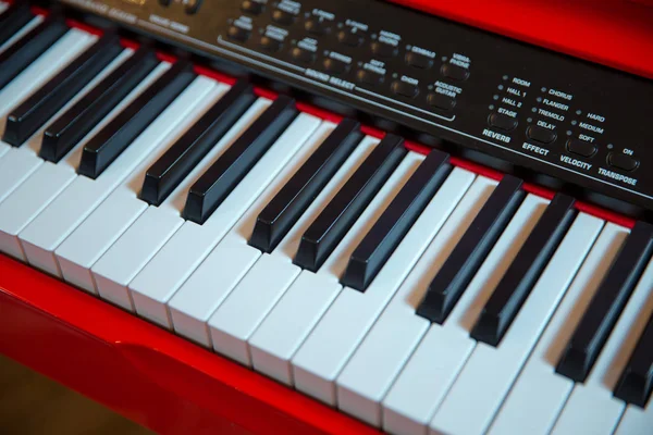Musik bakgrund i bred Panorama banner format, valda fokus, smala skärpedjup. Rött piano tangentbord med glansiga svarta och vita tangenter — Stockfoto