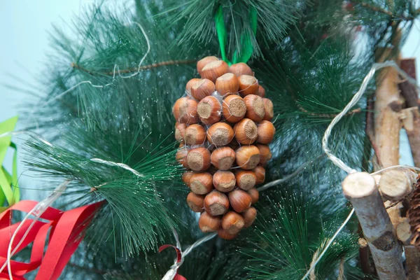 Weihnachtsdekoration in Form einer Hasel, im blauen Hintergrund zweigt Christbaum. schöner Weihnachtsschmuck. — Stockfoto