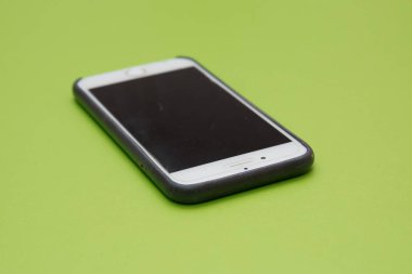 Siyah cep akıllı telefon mockup Ccw yeşil arka plan üzerinde izole boş ekran ile yüzeyde yatıyor döndürülmüş . Beyaz akıllı telefon yeşil arka planlar .