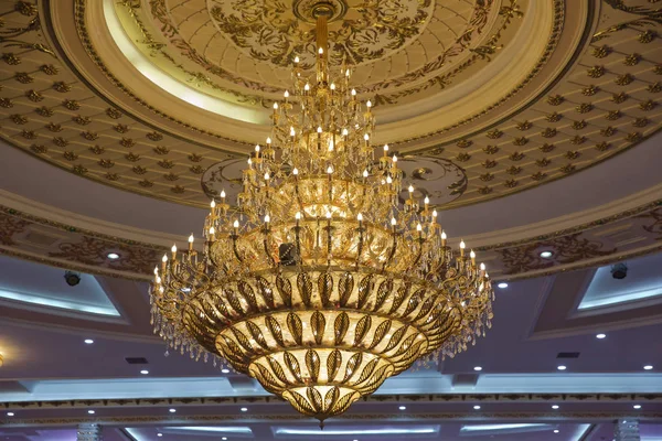 Gilded chandelier with burning candles in the Church. Large crystal chandelier in baroque style — Stock Photo, Image